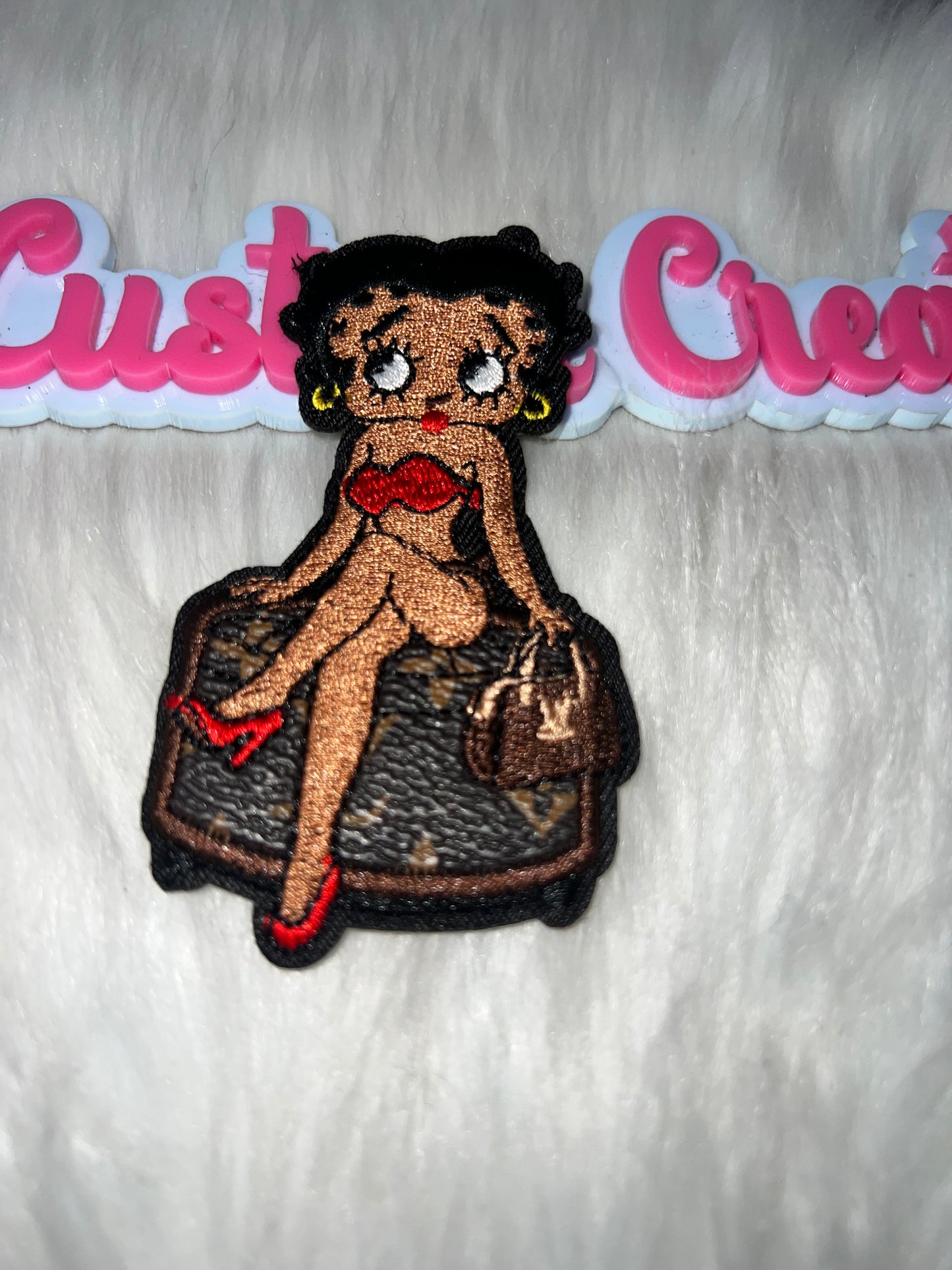 Betty-Style Girl Sitting on LV-Inspired Bag Patch